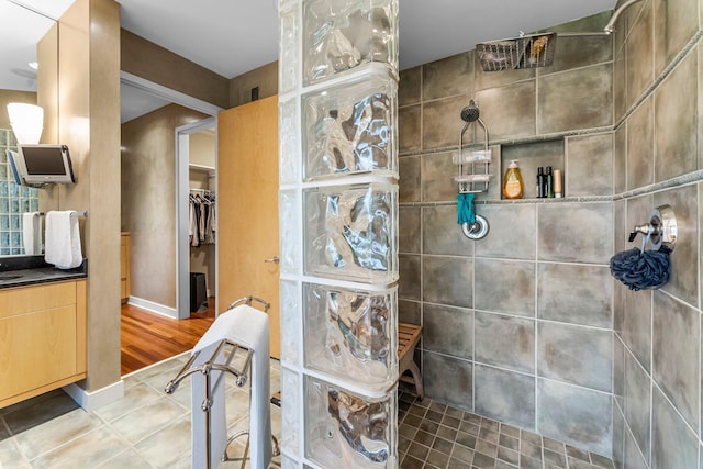 bathroom with vanity, a spacious closet, and walk in shower
