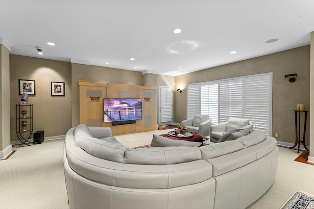 carpeted living area with baseboards and recessed lighting