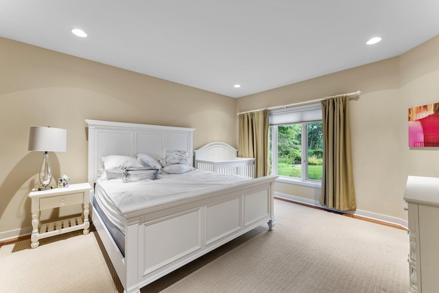 bedroom with baseboards, recessed lighting, and light colored carpet