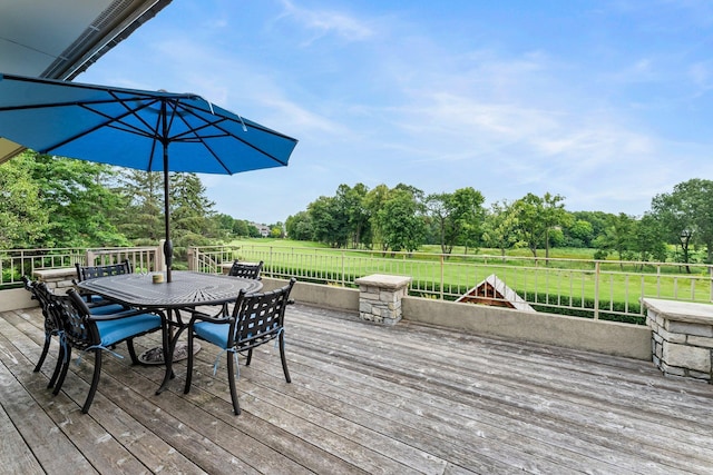 deck with a yard, fence, and outdoor dining area