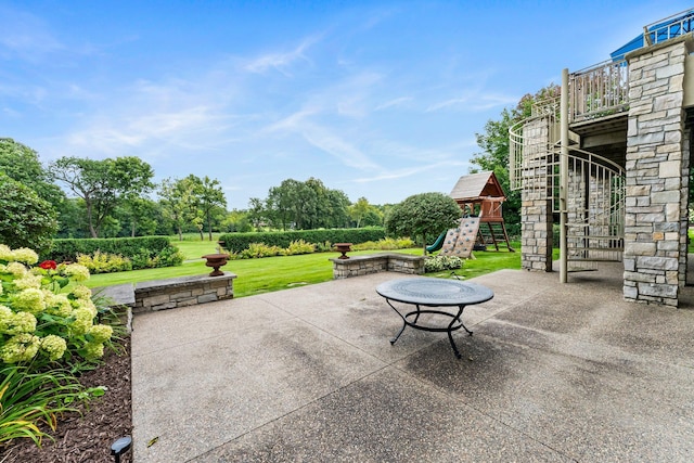 view of patio / terrace featuring a playground and stairs