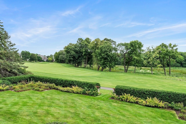 surrounding community with view of golf course and a lawn