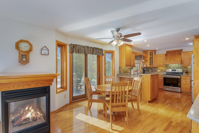 dining space with light hardwood / wood-style flooring, sink, and ceiling fan