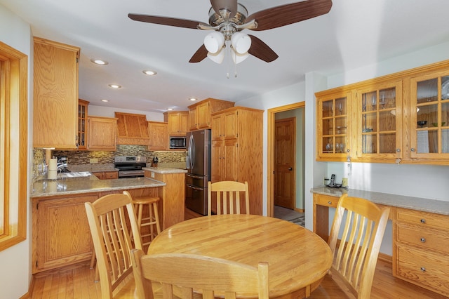 dining room with sink, light wood-type flooring, and ceiling fan