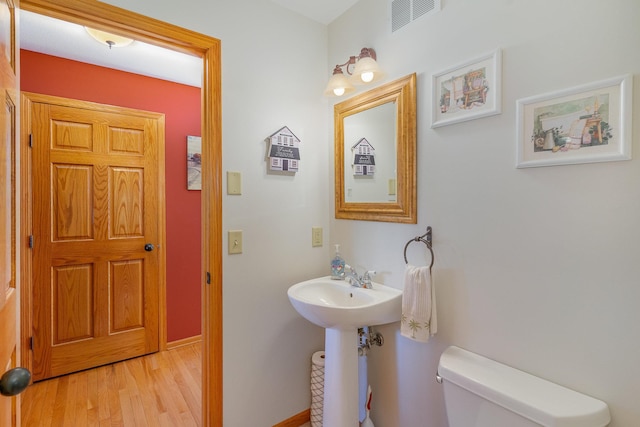 bathroom with toilet and wood-type flooring