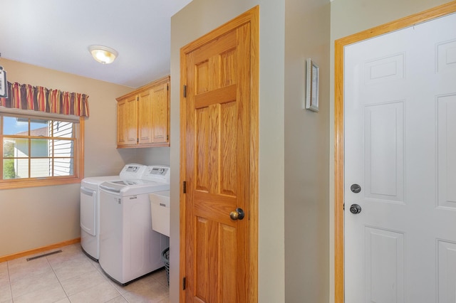 laundry area featuring cabinets, independent washer and dryer, and light tile patterned flooring