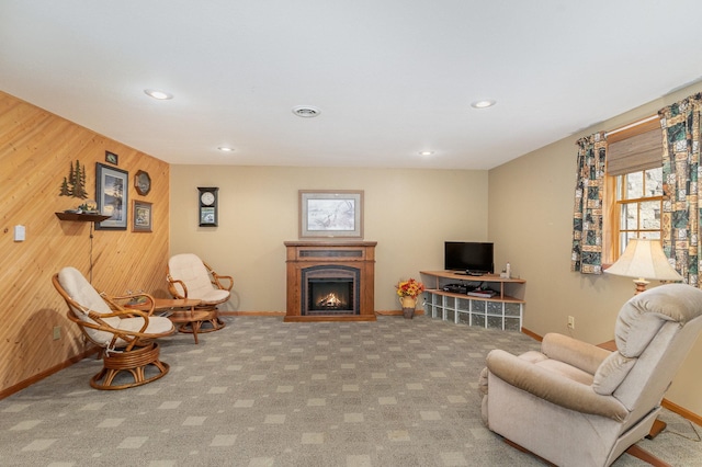 living area with wood walls and carpet