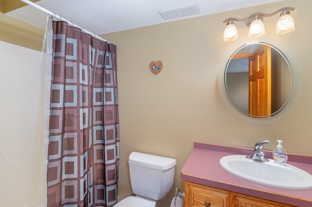 bathroom with vanity, curtained shower, and toilet