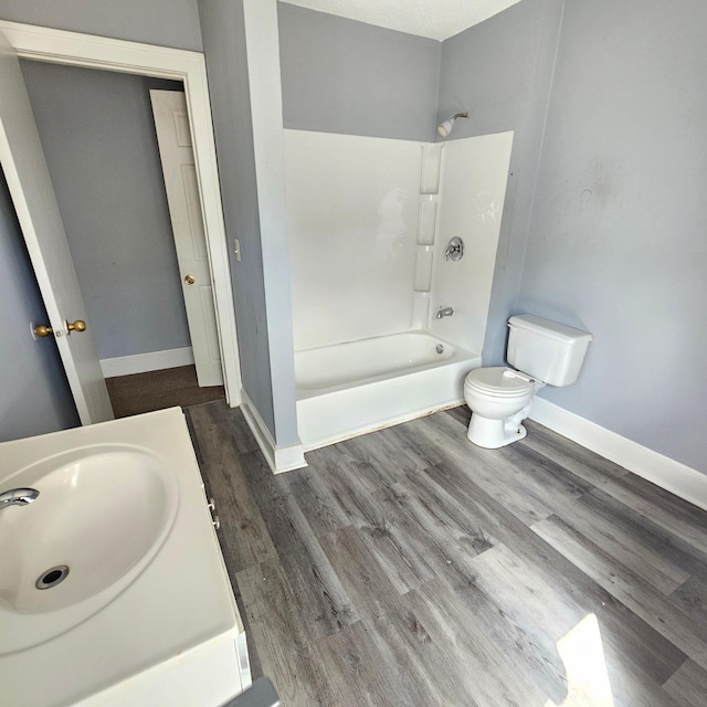 full bathroom with vanity, shower / washtub combination, hardwood / wood-style floors, and toilet