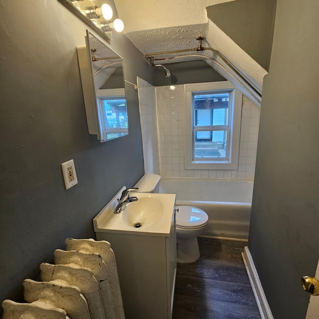 full bathroom with hardwood / wood-style floors, vanity, toilet, and tiled shower / bath