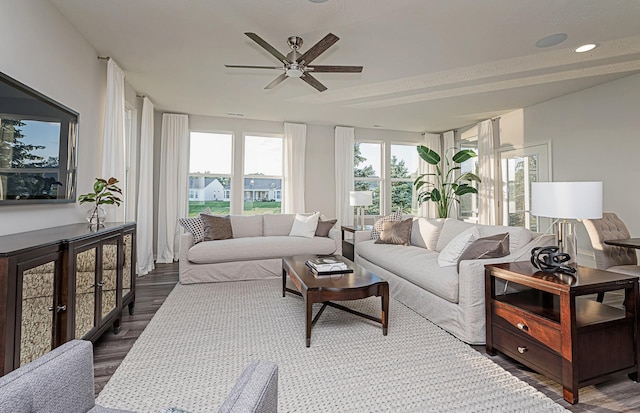 living room with dark hardwood / wood-style flooring and ceiling fan