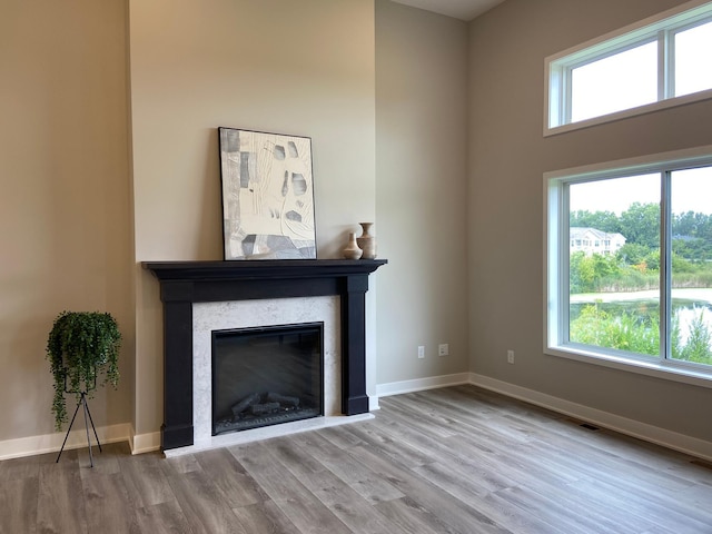 unfurnished living room with a high ceiling and light hardwood / wood-style floors