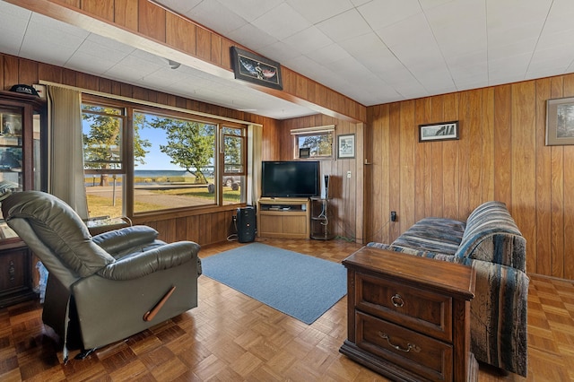 living room featuring wood walls and light parquet flooring