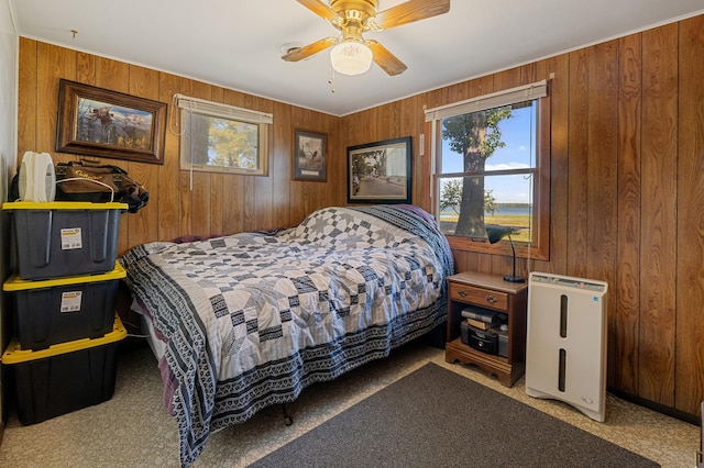 bedroom featuring light colored carpet, ceiling fan, and wood walls