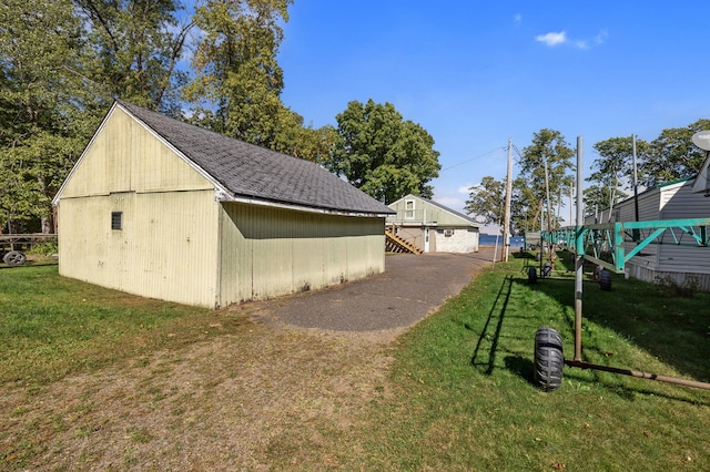 view of side of home featuring a yard and an outdoor structure