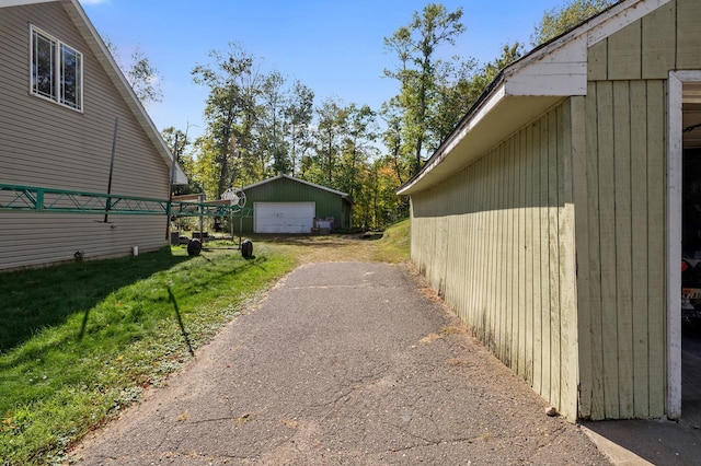 view of side of home with an outbuilding, a yard, and a garage