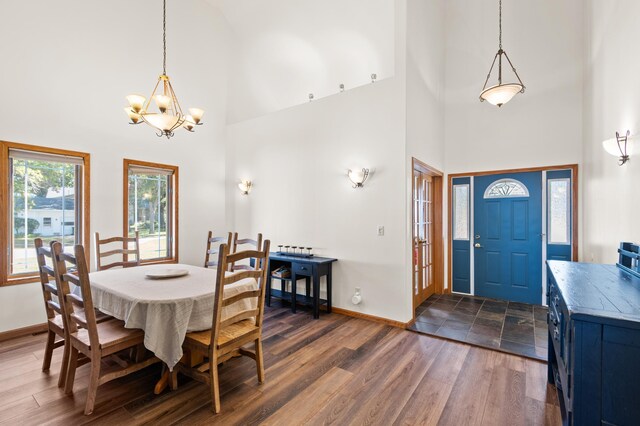 dining room with an inviting chandelier, a high ceiling, and dark wood-type flooring