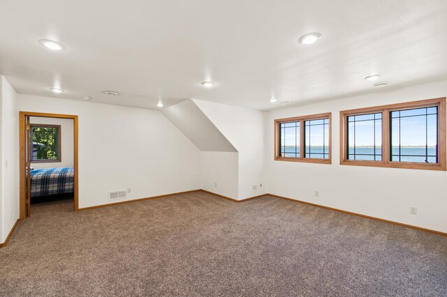 bonus room featuring carpet and a water view