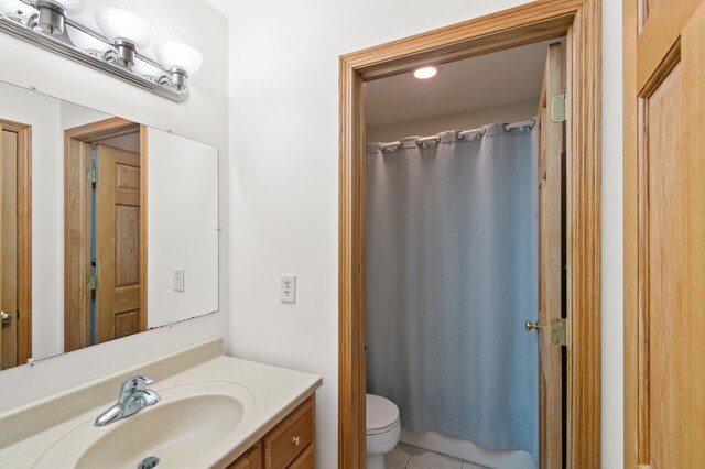 bathroom with tile patterned flooring, vanity, and toilet