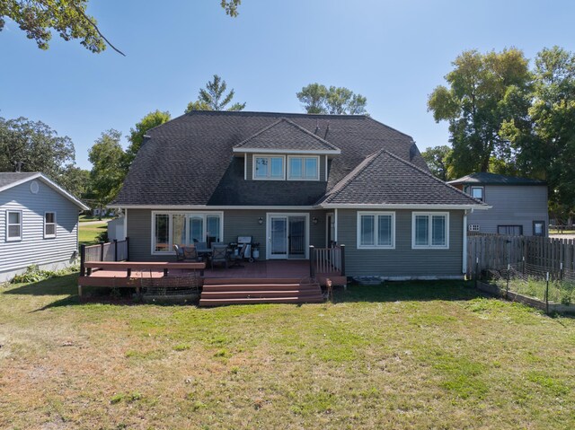 rear view of property featuring a deck and a yard