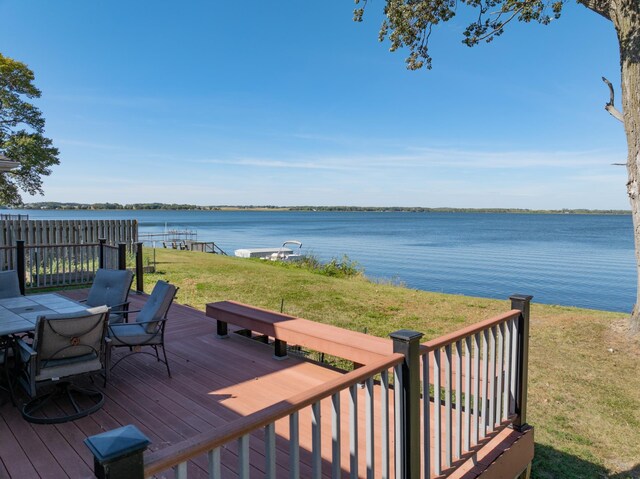 wooden terrace with a yard and a water view