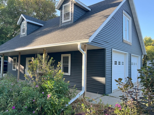 view of home's exterior featuring a garage and covered porch