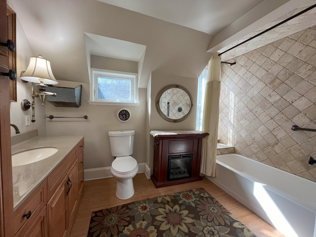 full bathroom featuring hardwood / wood-style flooring, vanity, toilet, and tiled shower / bath combo