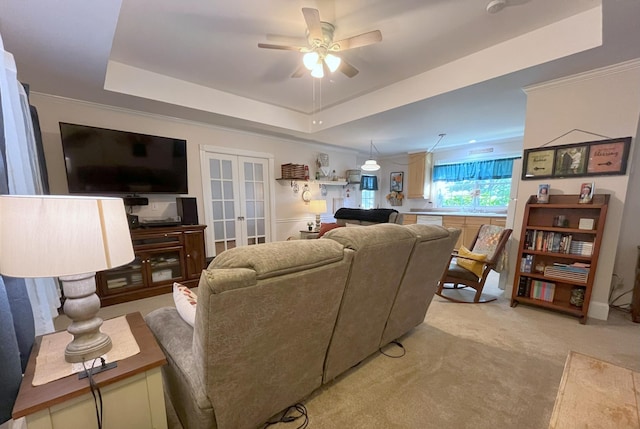 living room featuring sink, ceiling fan, french doors, light colored carpet, and a raised ceiling