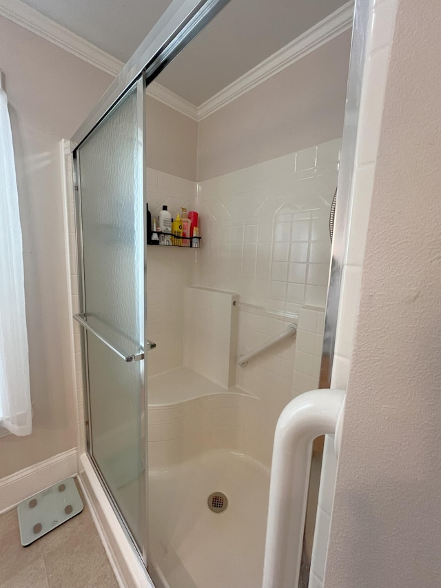 bathroom with crown molding, tile patterned floors, and a shower with shower door