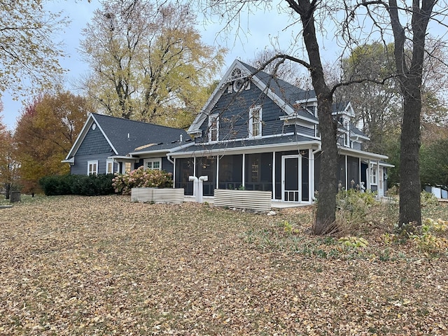 rear view of property featuring a sunroom