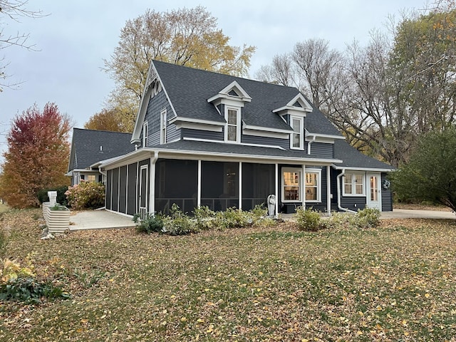 view of front of house with a patio area, a front lawn, and a sunroom