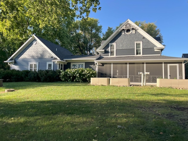 rear view of house with a sunroom and a lawn