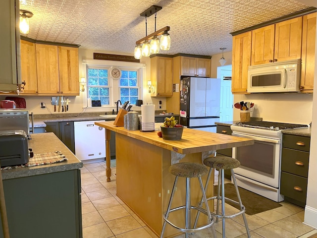 kitchen featuring a kitchen island, butcher block countertops, sink, hanging light fixtures, and white appliances