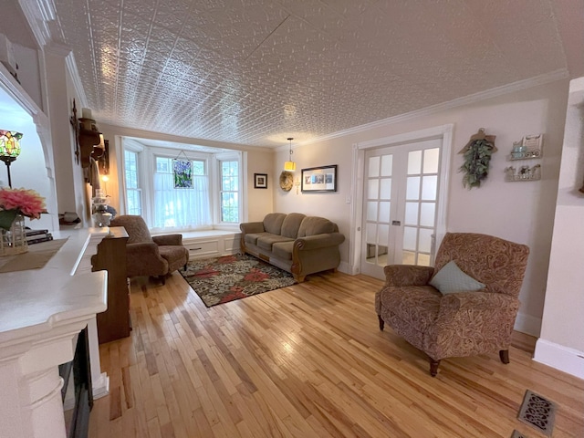 living room featuring french doors, crown molding, and light hardwood / wood-style flooring