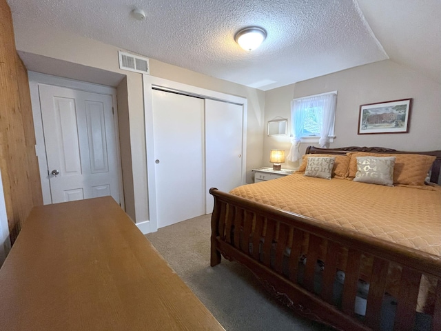 bedroom featuring light carpet, vaulted ceiling, and a textured ceiling