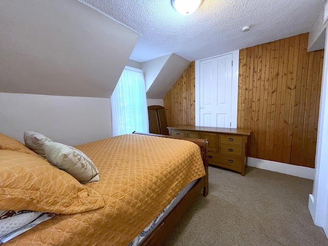 bedroom with vaulted ceiling, carpet, a textured ceiling, and wood walls