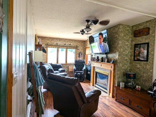 506 Ash Ave N, New Richland, MN 56072 - living room featuring wallpapered walls, wood finished floors, a glass covered fireplace, and ceiling fan