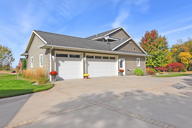 view of property exterior featuring a yard, a garage, roof with shingles, and concrete driveway