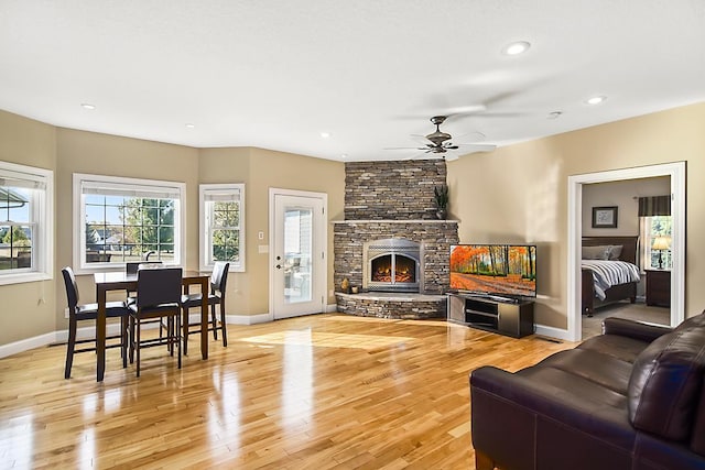 living area with light wood-type flooring, recessed lighting, a fireplace, baseboards, and ceiling fan