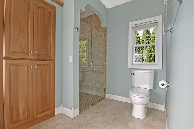 bathroom with tile patterned floors, a stall shower, toilet, and baseboards