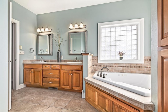 bathroom with double vanity, a garden tub, tile patterned floors, and a sink