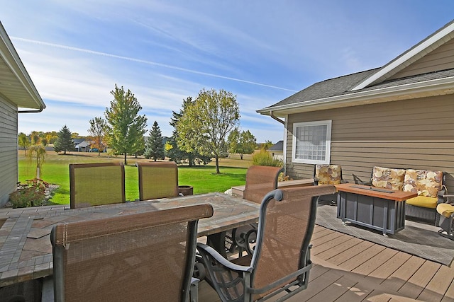 wooden terrace featuring a lawn, outdoor dining space, and outdoor lounge area