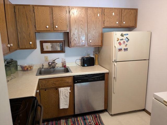 kitchen with dishwasher, white refrigerator, range, and sink