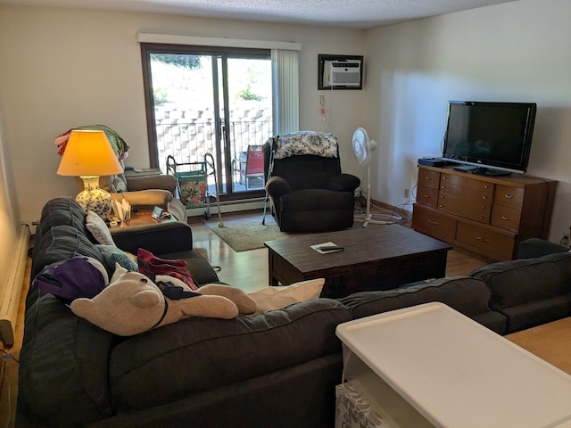 living room with hardwood / wood-style flooring, a textured ceiling, a baseboard heating unit, and a wall mounted AC