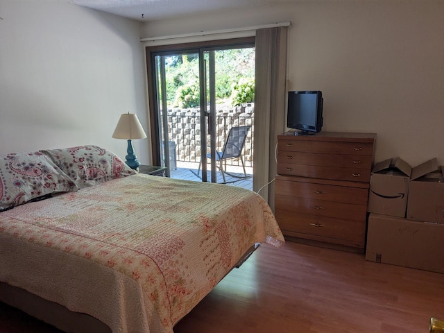 bedroom featuring hardwood / wood-style flooring and access to exterior