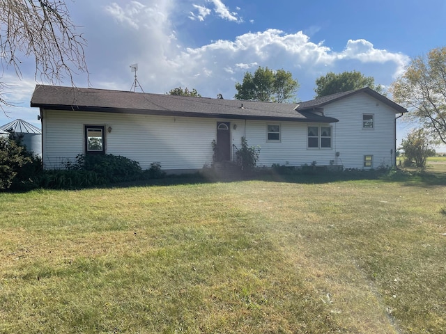 rear view of property featuring a yard