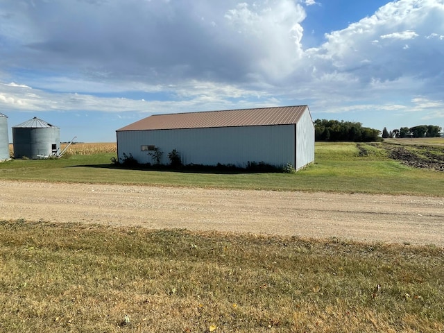 view of outbuilding with a rural view and a lawn