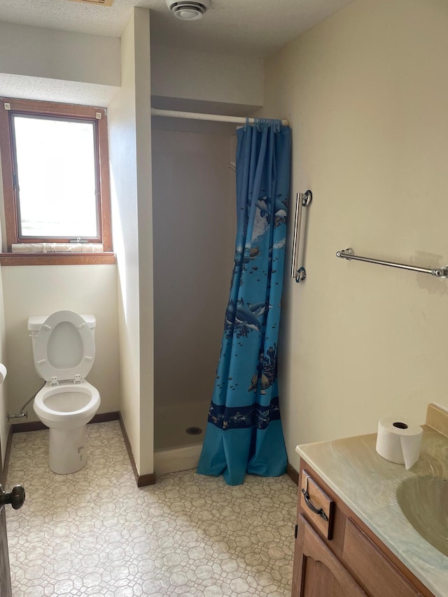 bathroom with toilet, vanity, and curtained shower