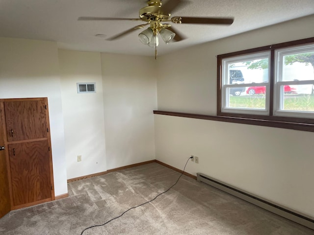 spare room with ceiling fan, a textured ceiling, baseboard heating, and light carpet