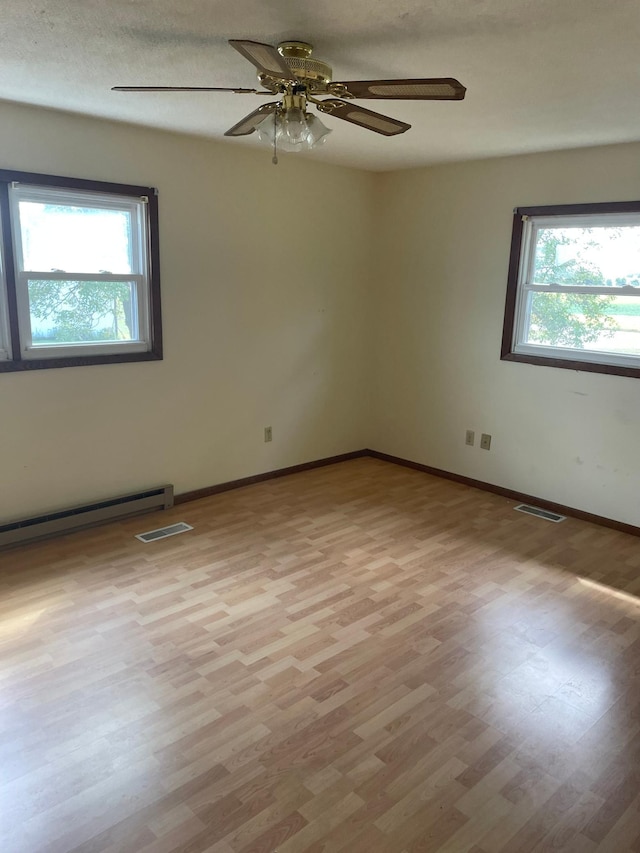 unfurnished room featuring a textured ceiling, a healthy amount of sunlight, light hardwood / wood-style floors, and ceiling fan